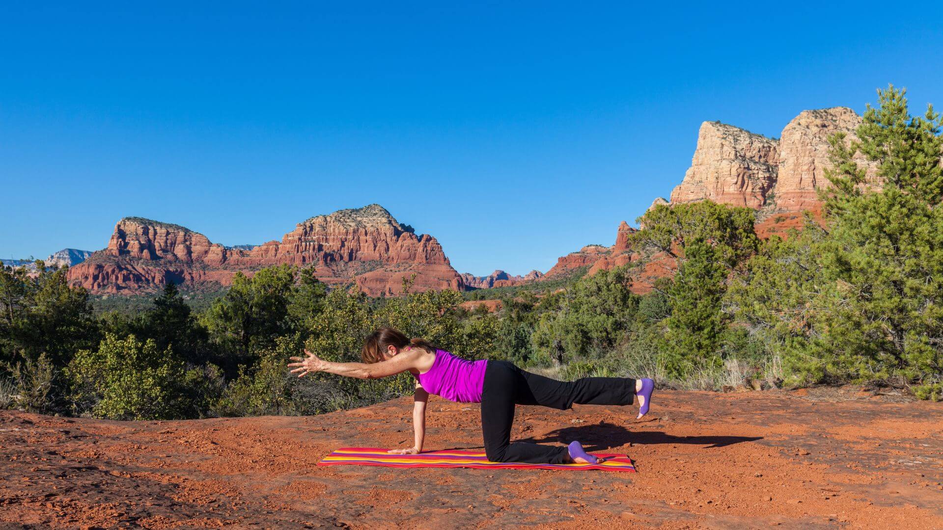 A woman practicing yoga in the red rocks of Sedona Arizona