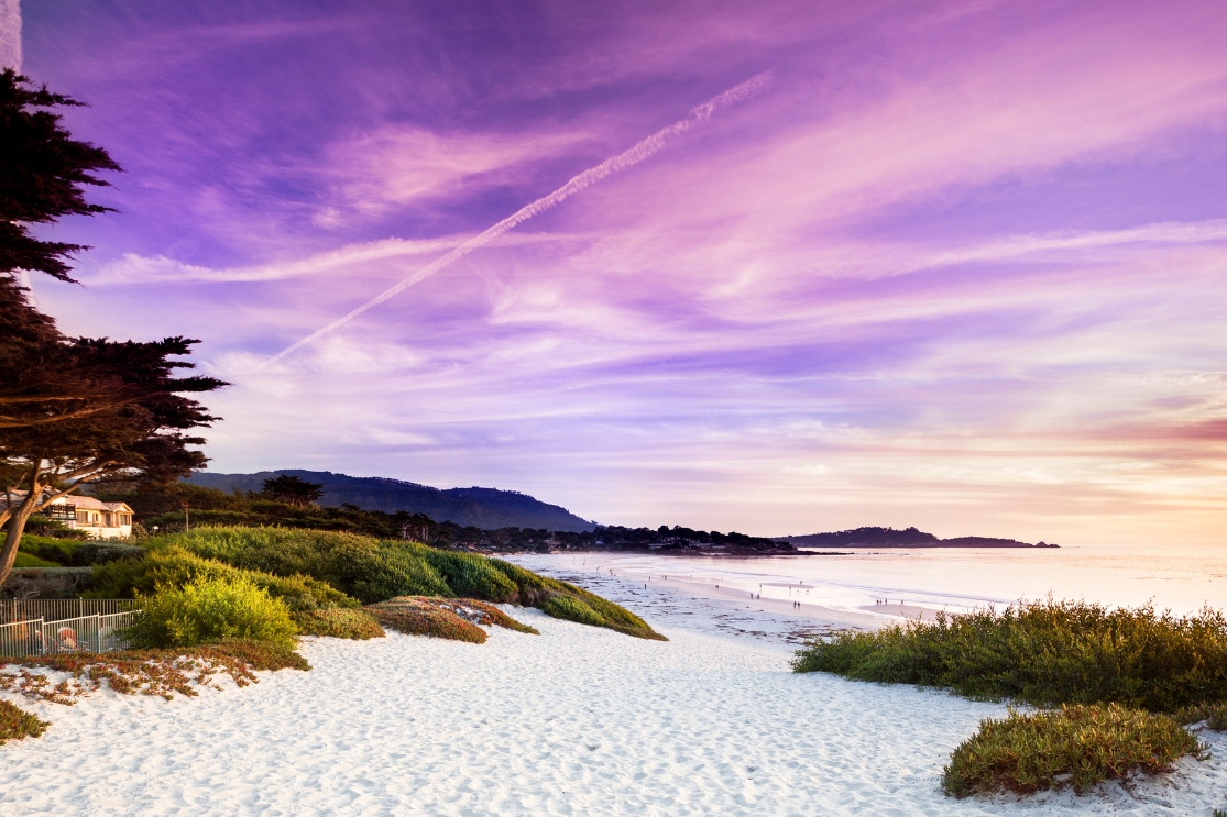 A purple sunset over the white sands of Carmel By The Sea, California